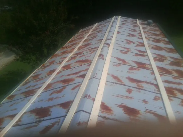 Rusted metal roof panels with new wood purlins before replacement — Storm Damage Roof Repair in Elizaville by Roofing Brothers